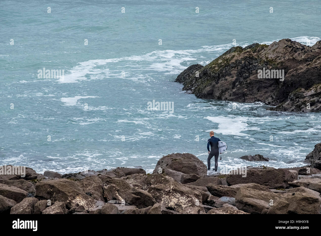 Ein Surfer schaut auf das Meer bei wenig Fistral in Newquay, Cornwall Stockfoto