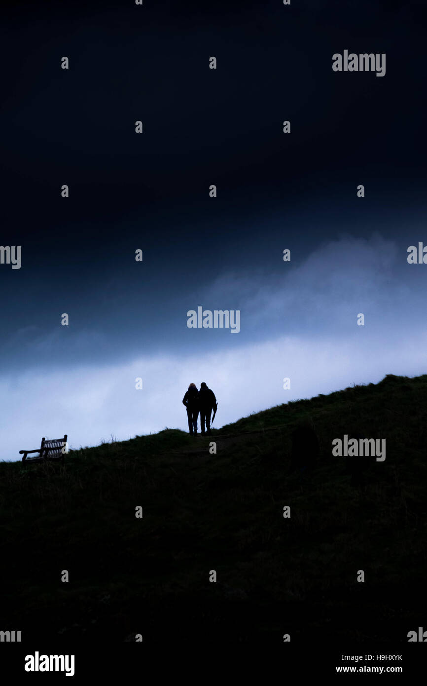Zwei Personen in der Silhouette zu sehen, wie sie auf Towan Landzunge in Newquay, Cornwall Fuß. Stockfoto