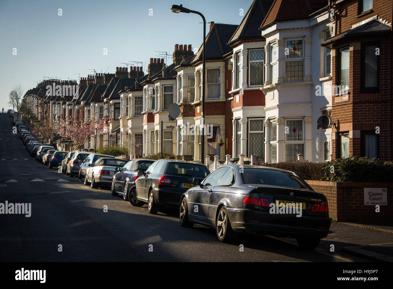 Terrassenförmig angelegten Häuser und Zeile des Autos vom Green Lanes in Harringay, Nord-London Stockfoto