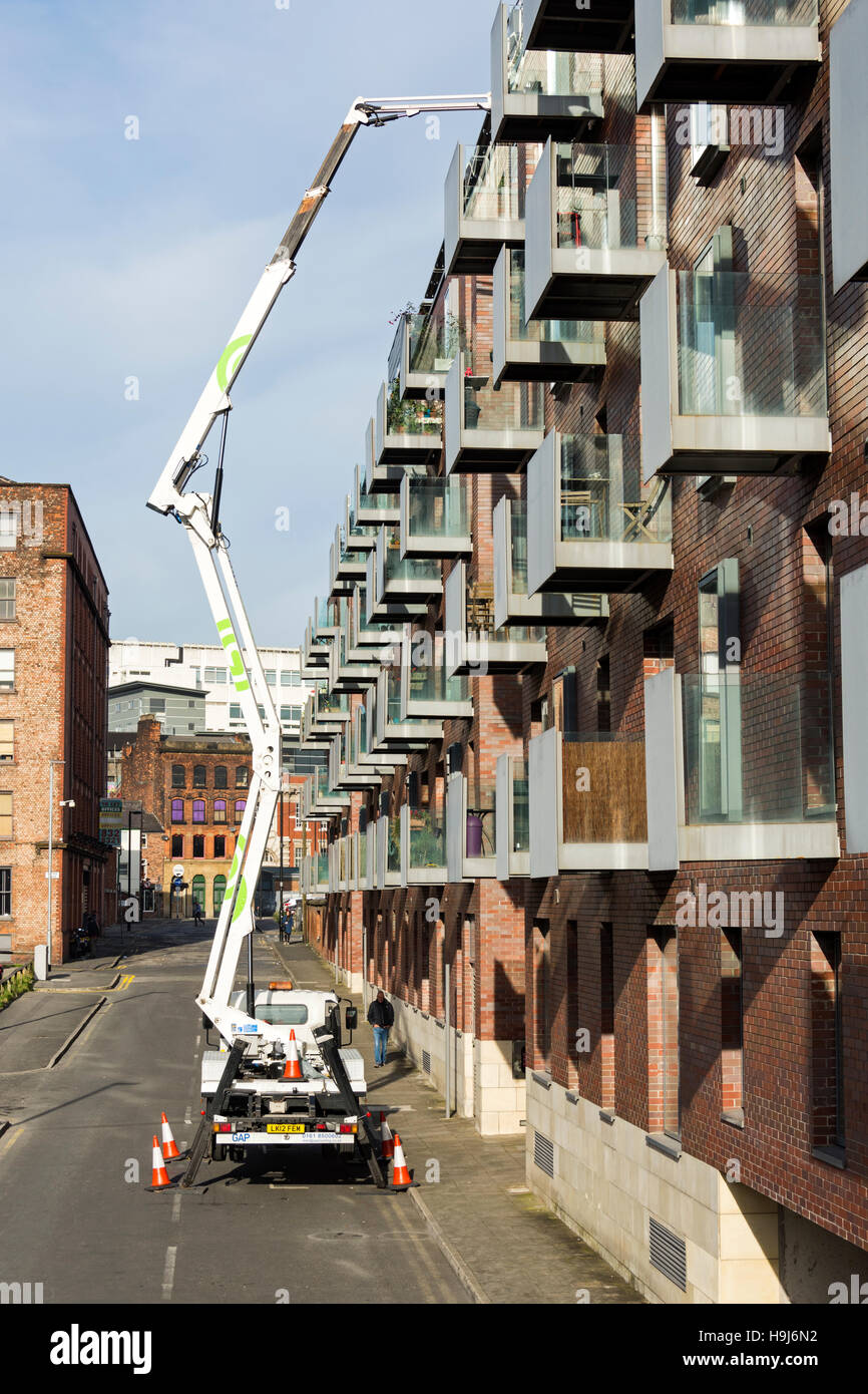 Access-Plattform (Hubarbeitsbühne) neben einem Wohnblock mit Balkonen, Stadtzentrum von Brewer Street, Manchester, UK Stockfoto