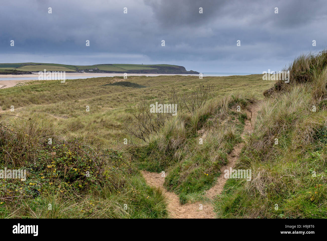 Blick über Sanddünen zu Padstow Bay unter stürmischen Winterhimmel. Die Mündung des Flusses Camel ist ein beliebtes Ziel für einen Familienurlaub. Stockfoto