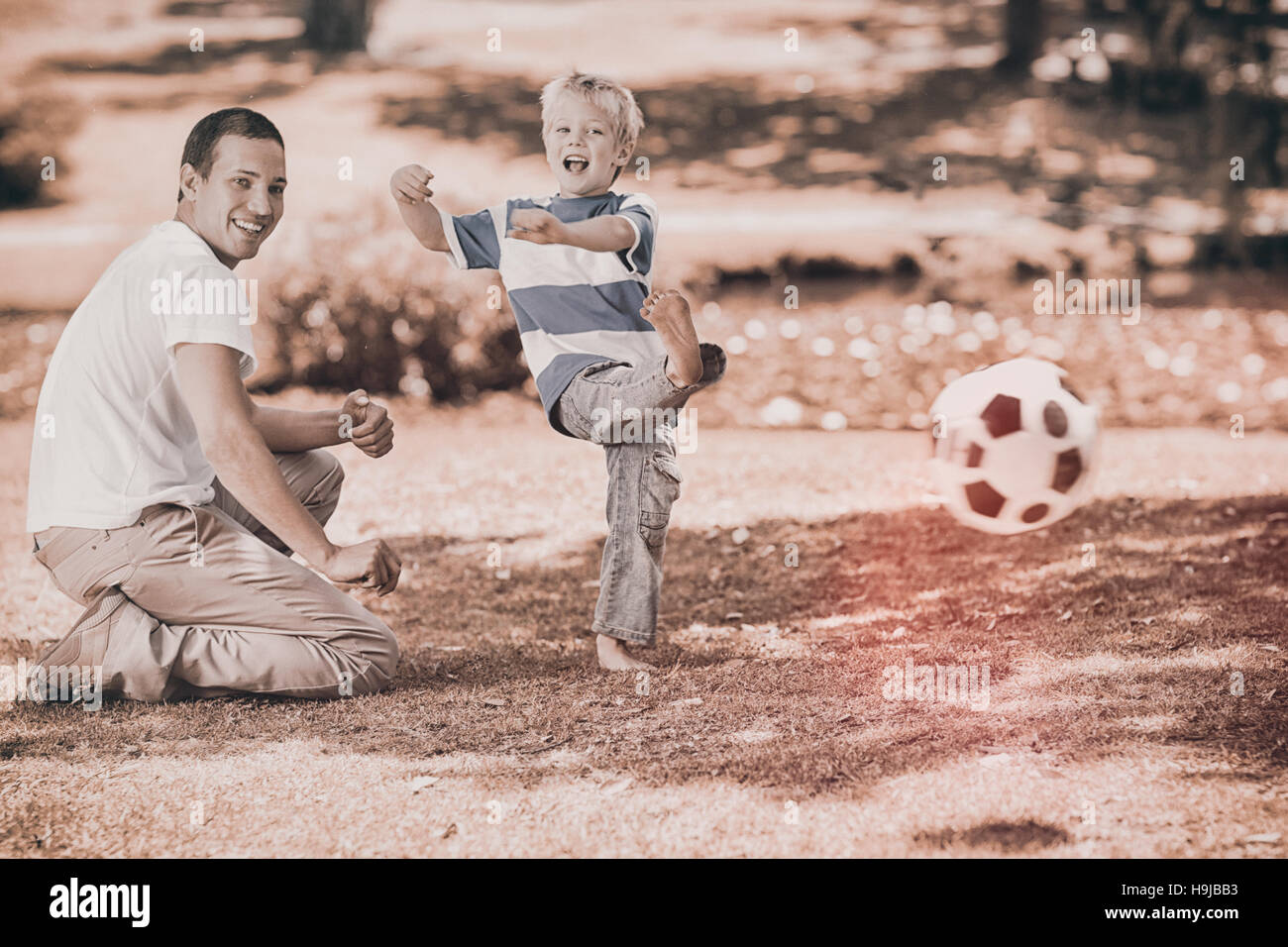Vater spielen Fußball mit seinem Sohn im Sommer Stockfoto