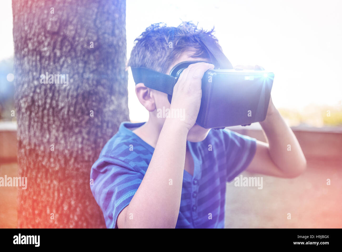 Elementare junge Blick durch virtual-Reality-Kopfhörer in der Schulbibliothek Stockfoto