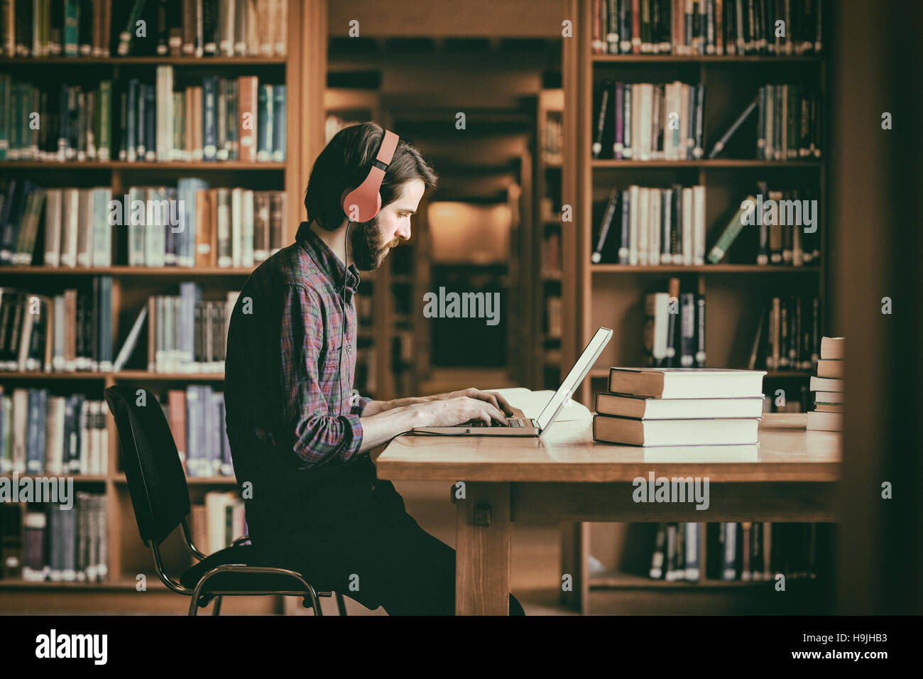 Hipster-Studierender in Bibliothek Stockfoto