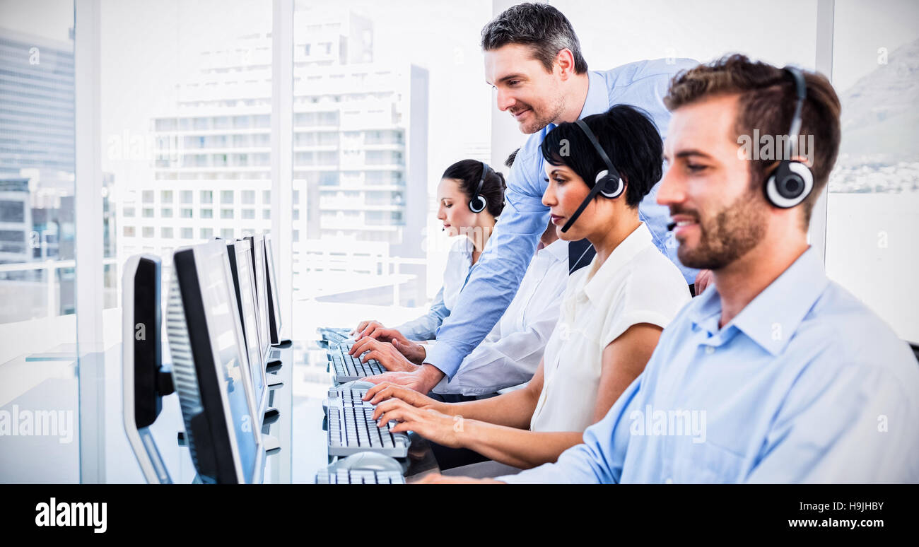 Manager und Führungskräfte mit Headsets, die mit dem Computer Stockfoto