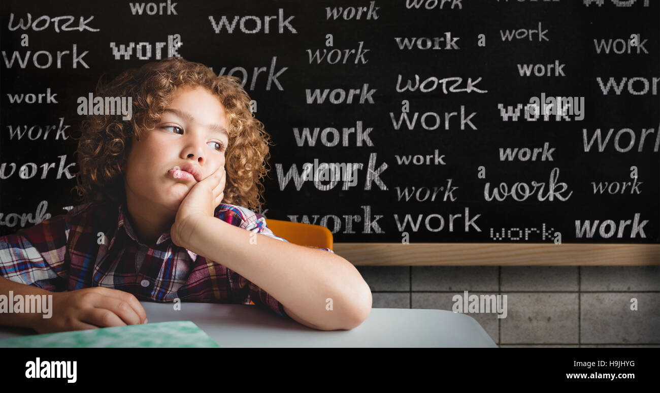 Zusammengesetztes Bild der Schuljunge sitzt an einem Schreibtisch Stockfoto