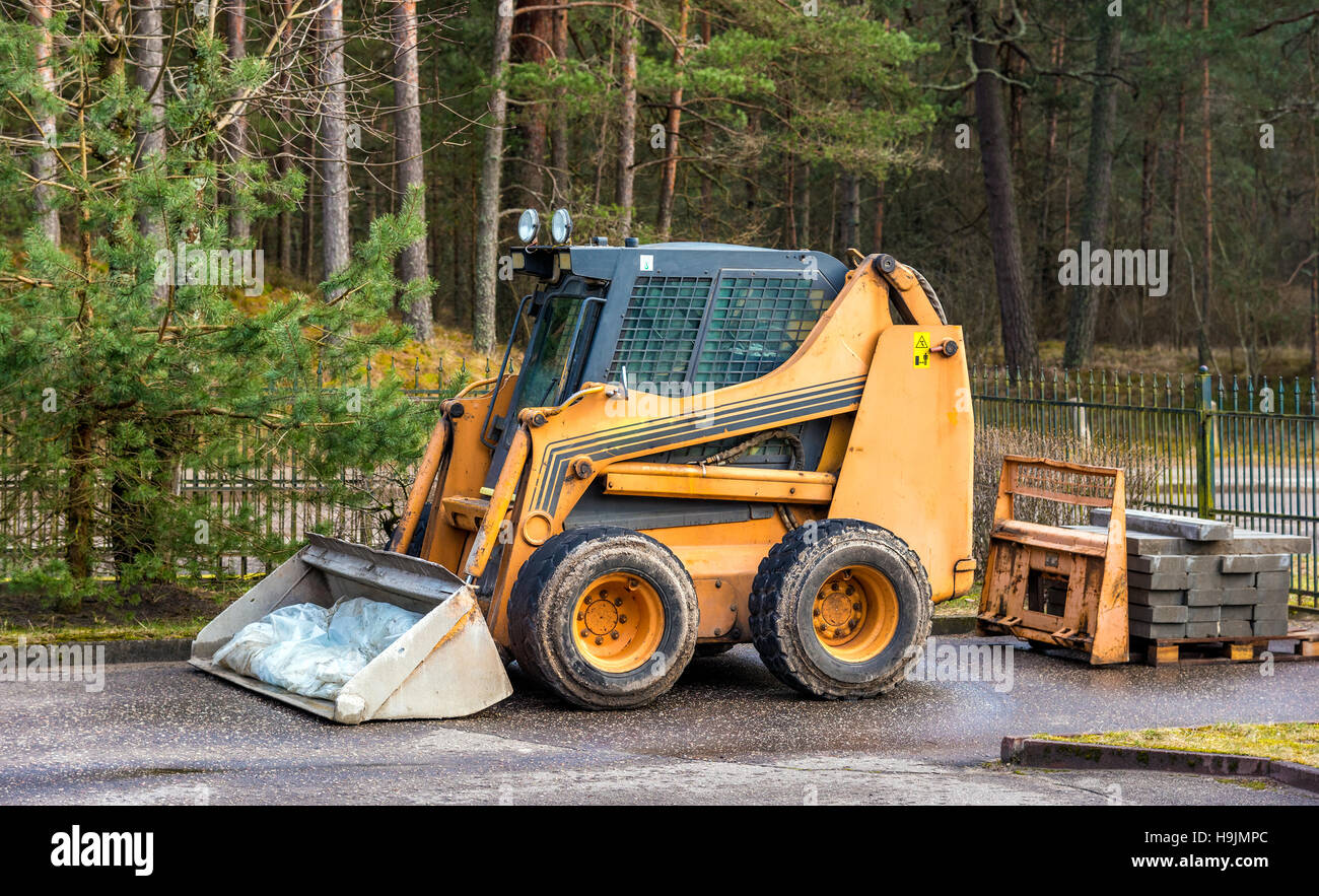 Bobcat oder Skid Loader geparkt im Wald Stockfoto