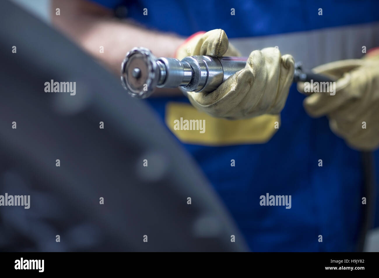 Mechaniker hält der Reifen-Lauffläche-Schneidemaschine Stockfoto