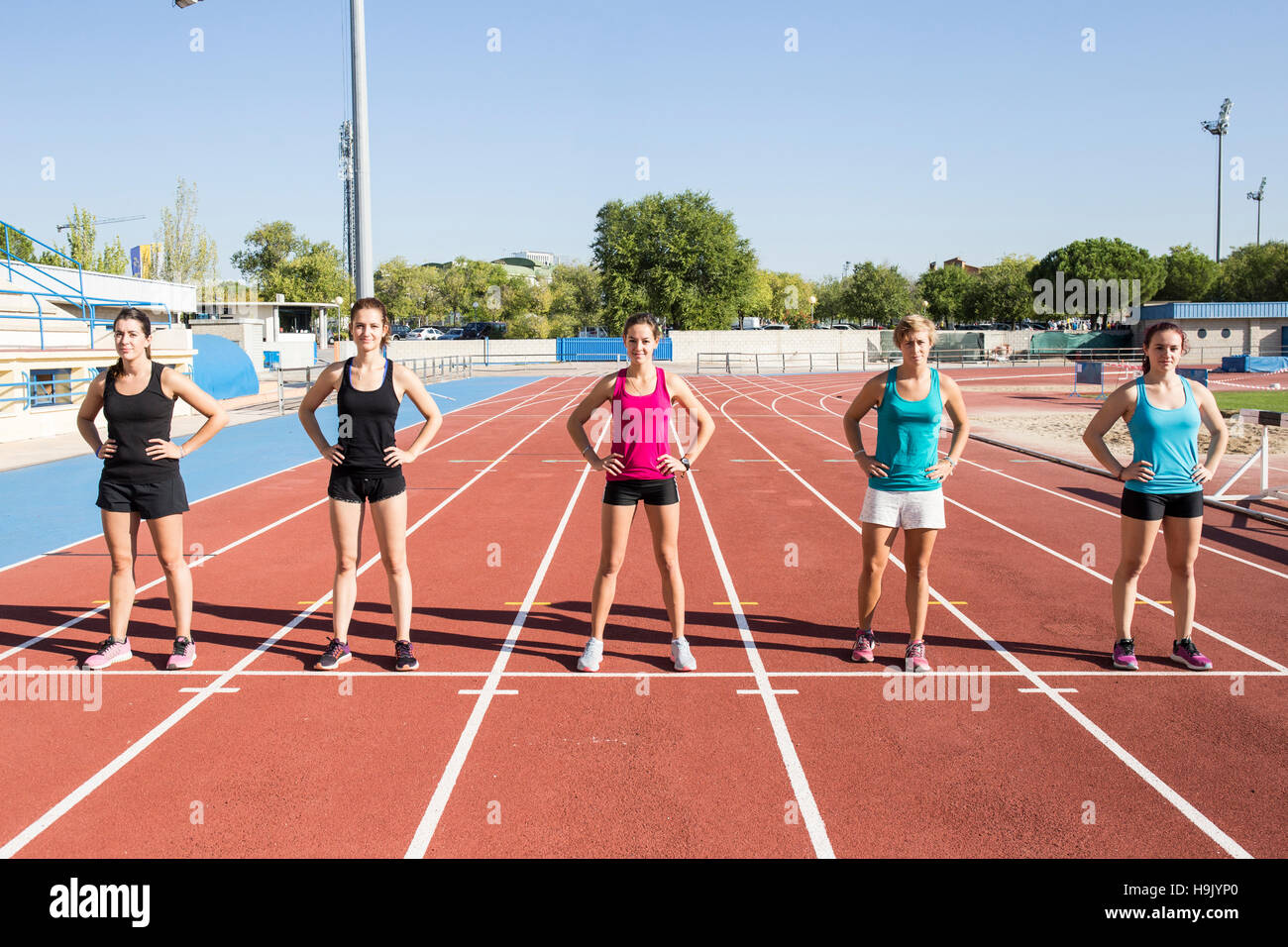 Läuferinnen auf Tartan stehend verfolgen am Start Stockfoto