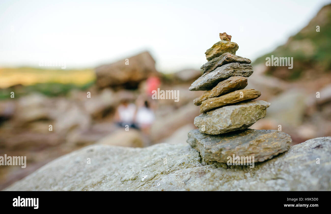 Stapel aus Stein mit unscharfen Menschen im Hintergrund Stockfoto