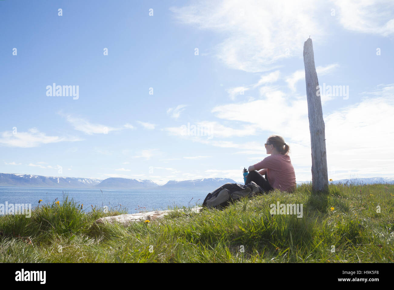 Island, Wanderer ruht auf einer Wiese betrachten Stockfoto
