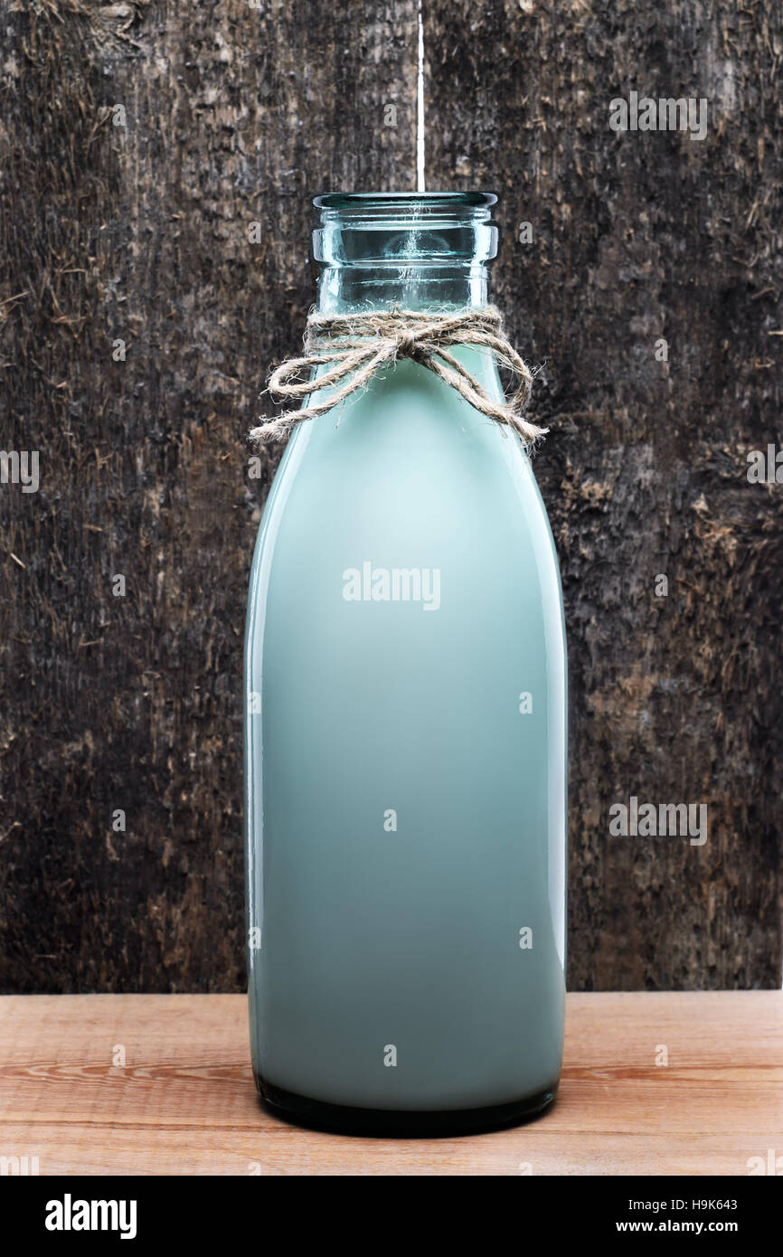 Alten Stil Flasche frische Milch auf rustikalen Holztisch auf hölzernen Hintergrund. Stockfoto
