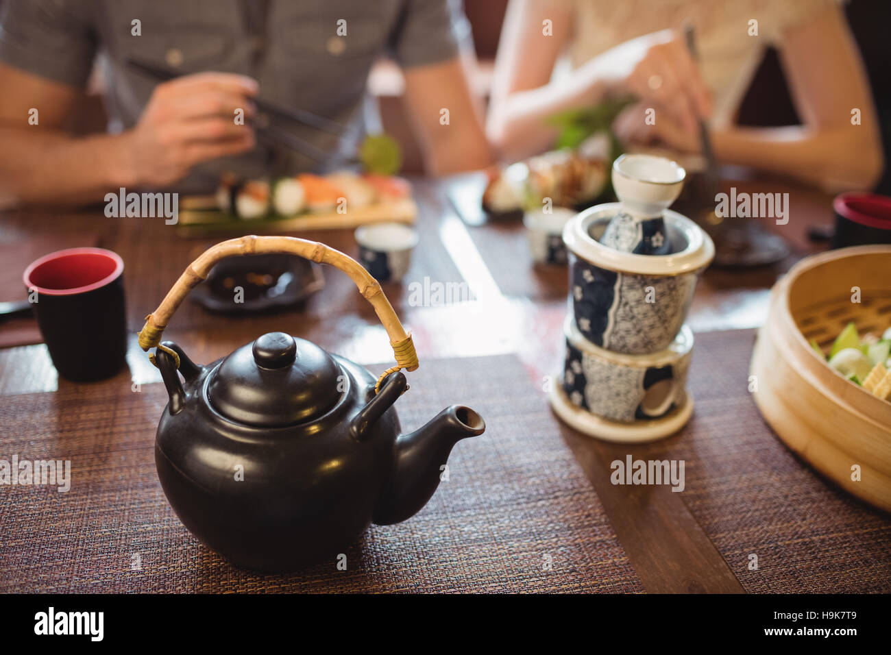 Teekanne und Tasse auf Esstisch Stockfoto