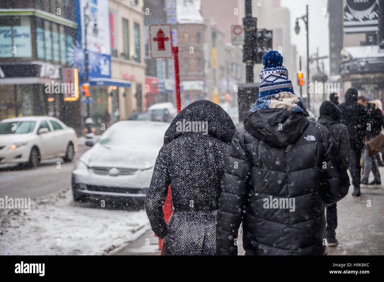 Montreal, CA - 21. November 2016: erste Schnee der Saison trifft die Stadt. Fußgänger in Sainte-Catherine Street im Stadtzentrum. Stockfoto