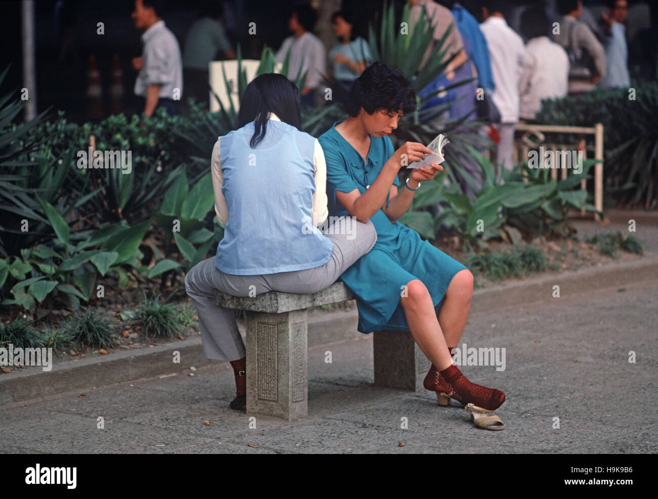 Ein paar von Fabrikarbeitern in der Mittagspause lesen Comics, Hangzhou, Zhejiang Provinz, China Stockfoto