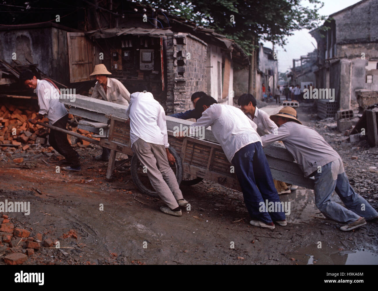 Männer schleppen schwere Betonplatte für den Bau Bau, Hangzhou, Zhejiang Province, China Stockfoto