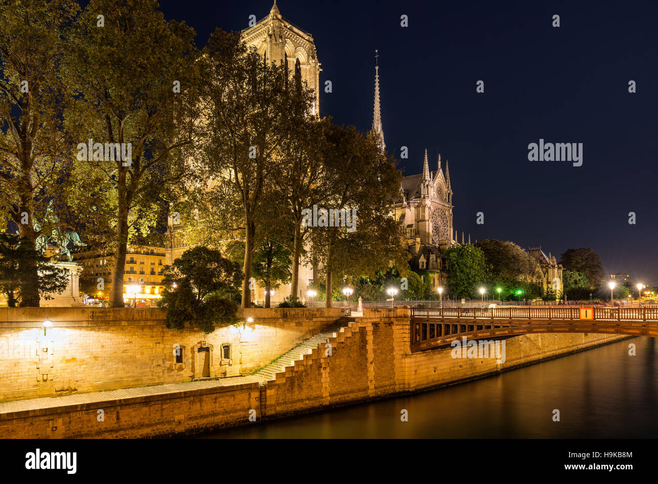 Kathedrale Notre Dame de Paris beleuchtet in der Dämmerung mit dem Seineufer und dem Pont au Double. Ile De La Cite. Paris, Frankreich Stockfoto