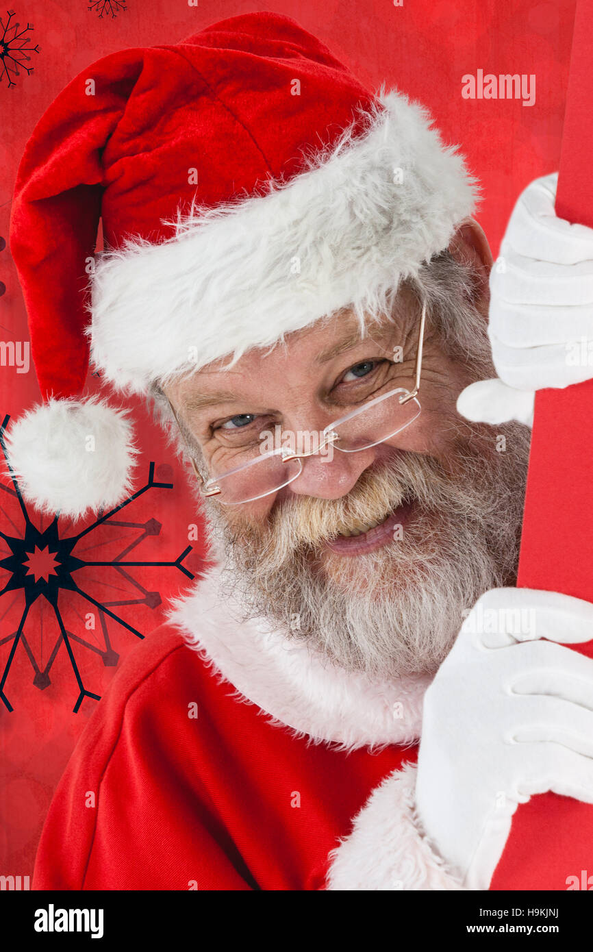 Zusammengesetztes Bild von Close-up Santa Claus spähen aus roten board Stockfoto