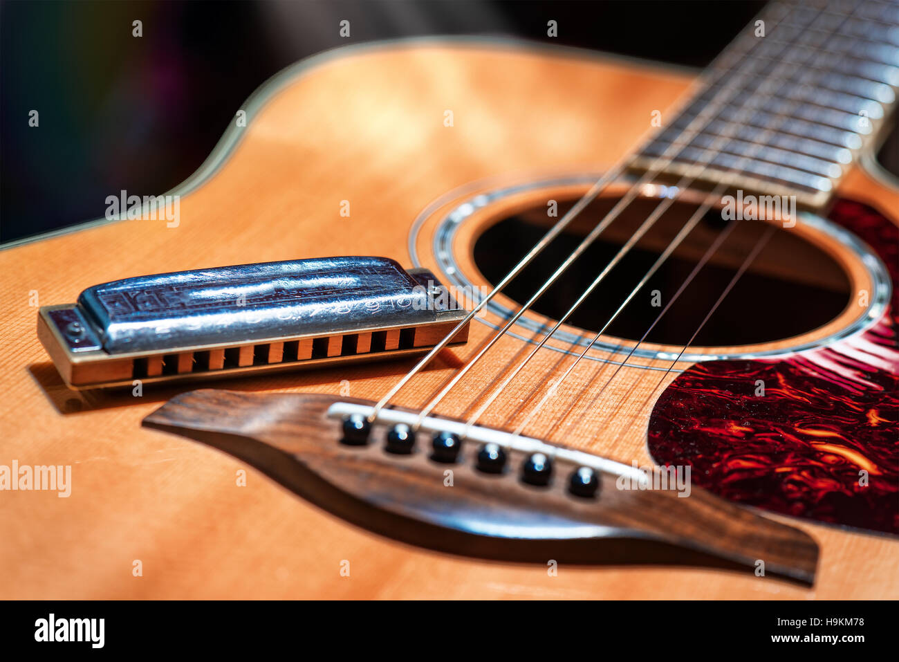 Akustikgitarre mit Country Blues Mundharmonika auf der Bühne bereit Stockfoto