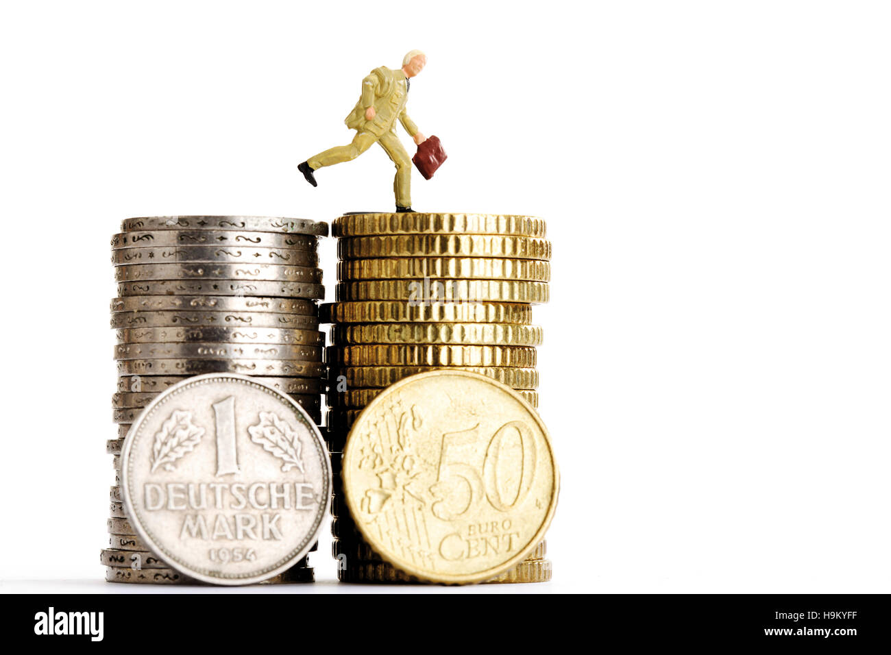 Stapel von Euro und D-Mark-Münzen, Figur eines Managers mit einer Datei Stockfoto
