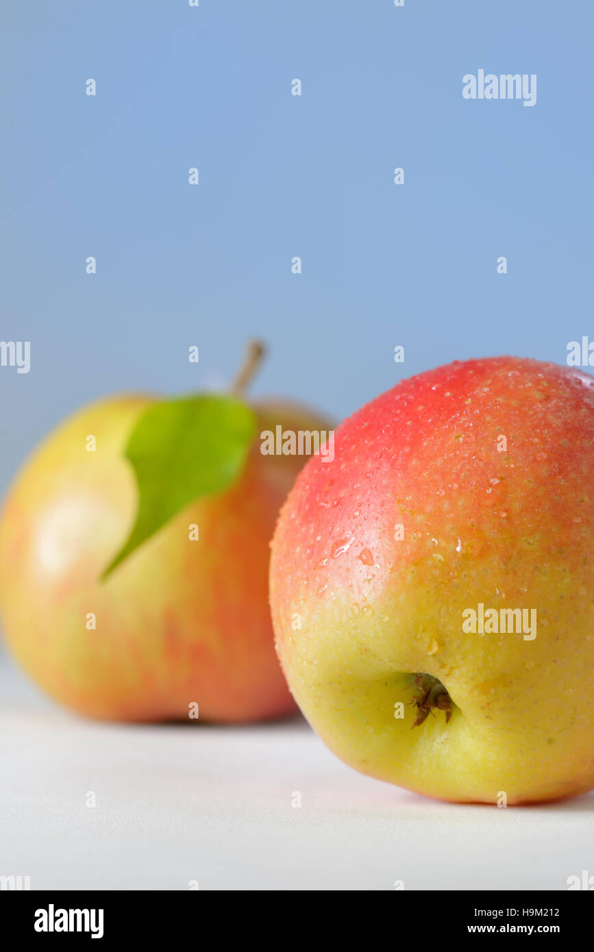 Äpfel mit Tautropfen auf Tisch Stockfoto