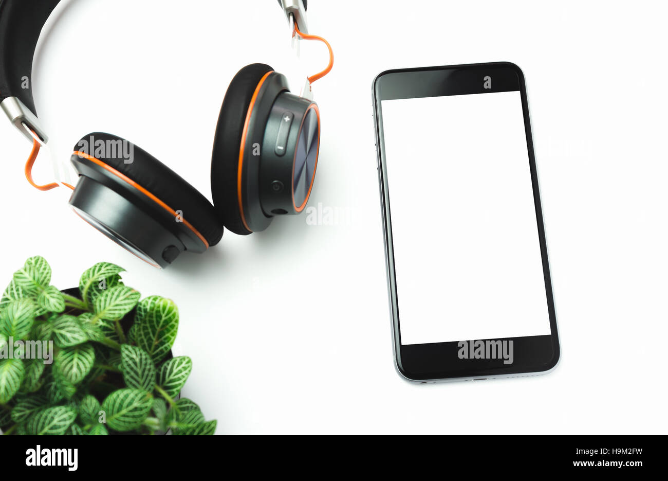 Telefon-Headsets und Baum auf einem Holztisch. Stockfoto