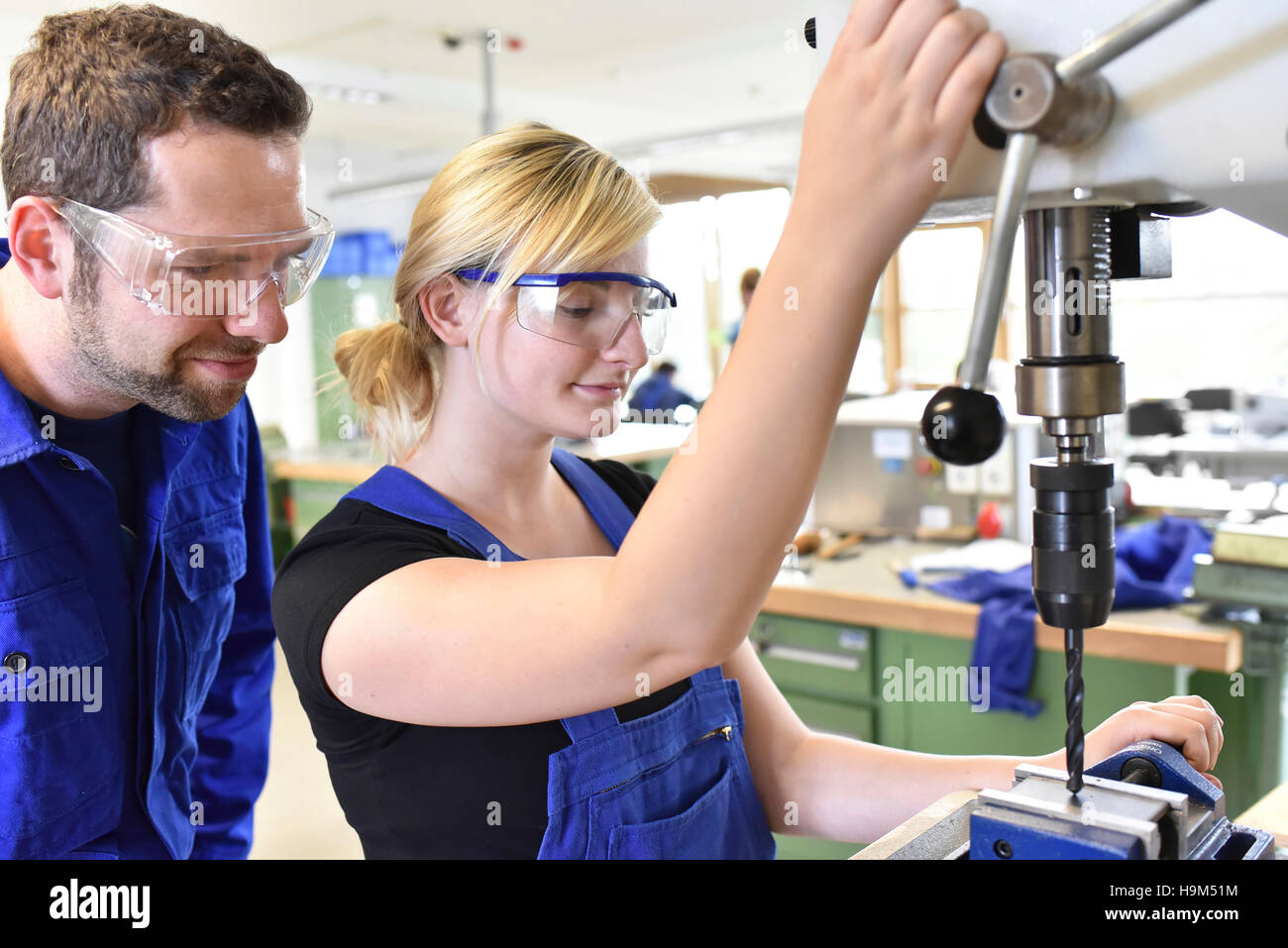 Lehrer mit weiblichen Trainee bei Bohrmaschine Stockfoto