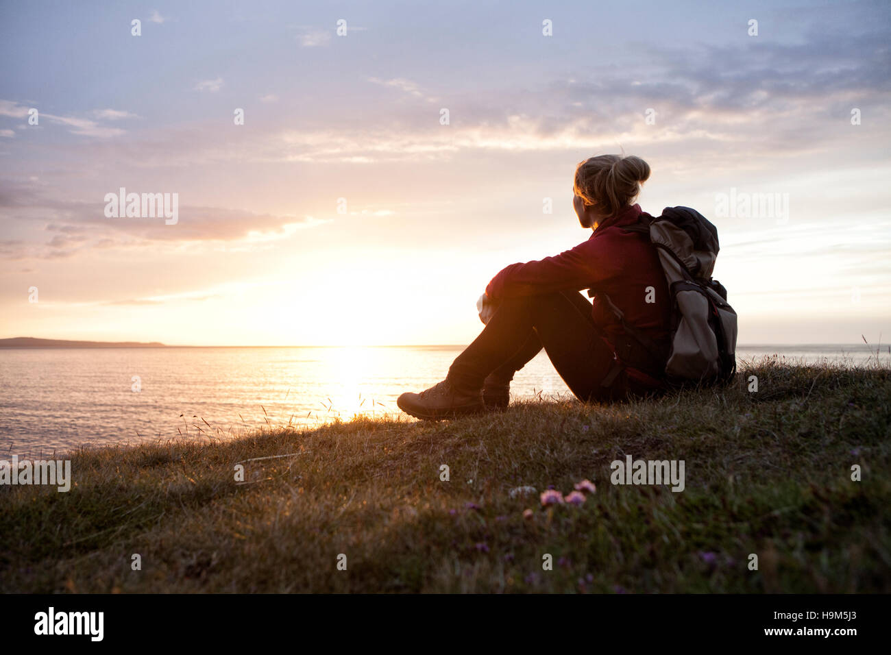Island, Wanderer sitzen auf einer Wiese betrachten von twilight Stockfoto