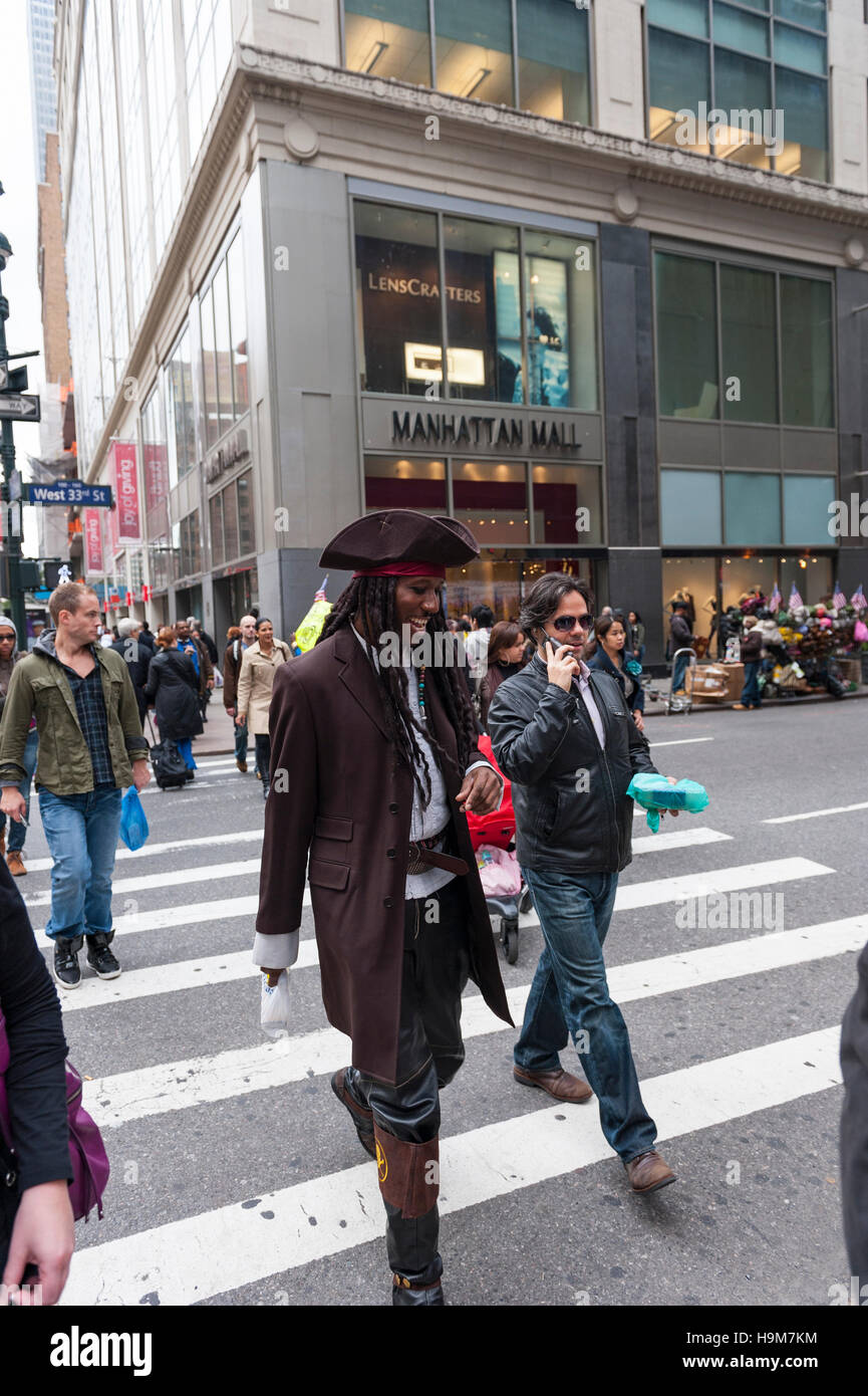 Ein afrikanisch-amerikanischer Erwachsener Mann mit einem Jack Sparrow Kostüm überquert den Fußgängerweg in New York City Stockfoto