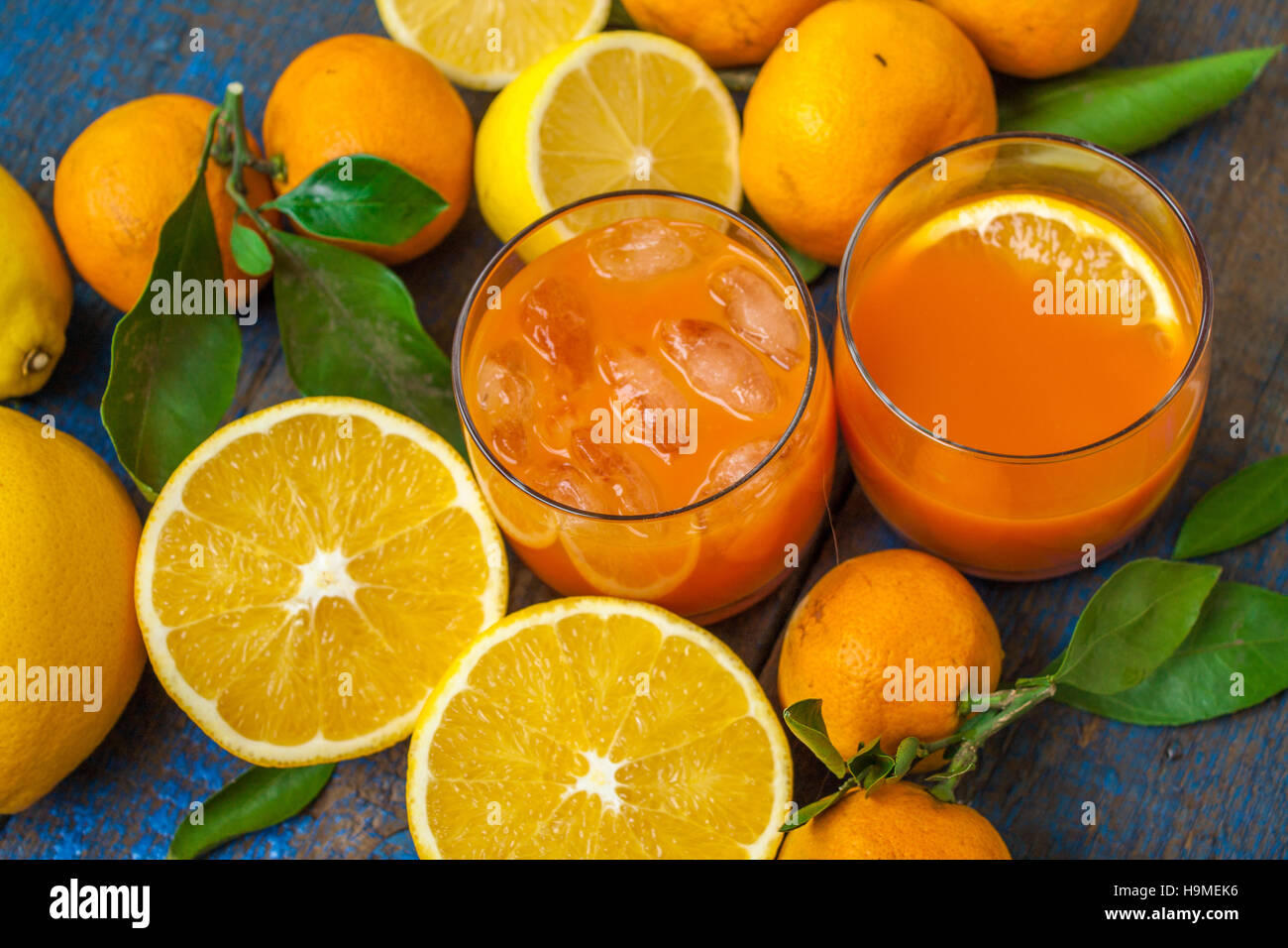 Gesunde frische Zitrusfrüchte Saft (zwei Gläser), Orangen, Mandarinen, Zitronen, Eis, Blätter.  Liebe für eine gesunde Rohkost-Konzept Stockfoto