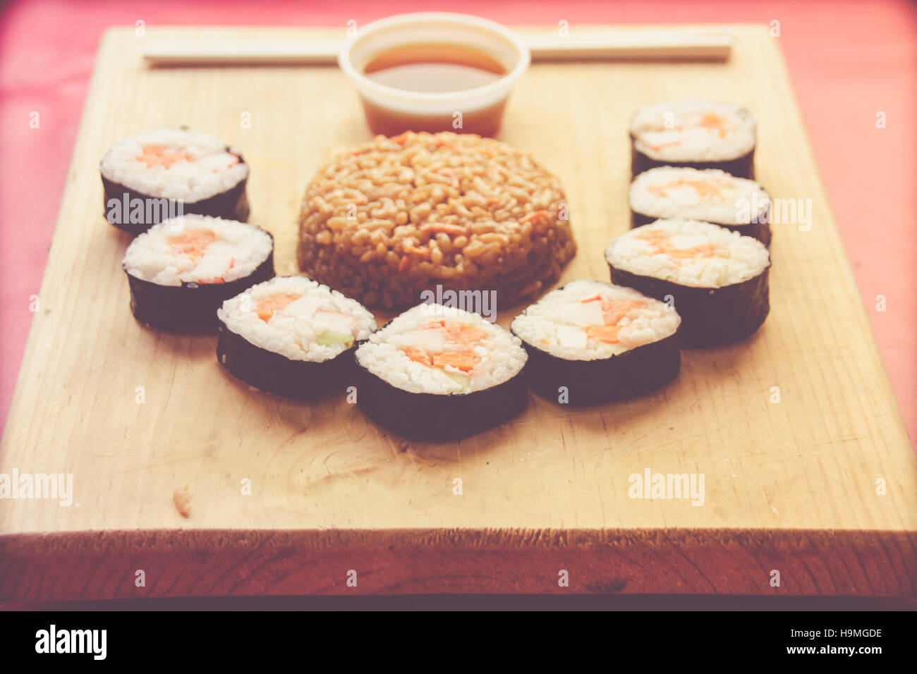 Phtograph einige Sushi Rollen Scheiben und gebratenen Reis auf einem Holztisch Stockfoto