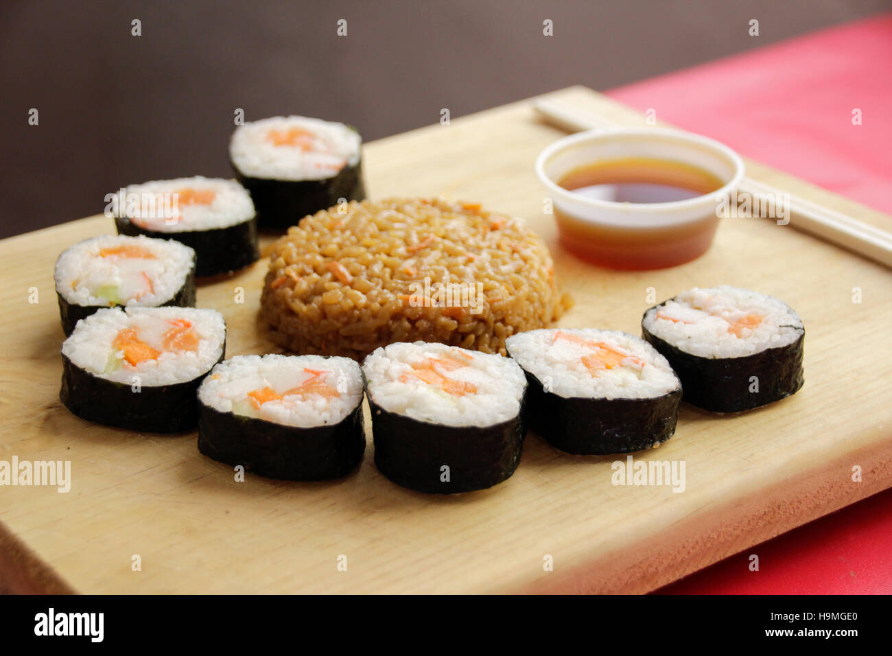 Phtograph einige Sushi Rollen Scheiben und gebratenen Reis auf einem Holztisch Stockfoto