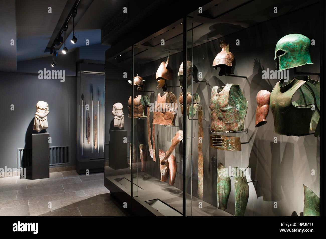 Brustplatte und Helme in einer beleuchteten Vitrine, Museum of Antiquities, Mougins, Frankreich Stockfoto