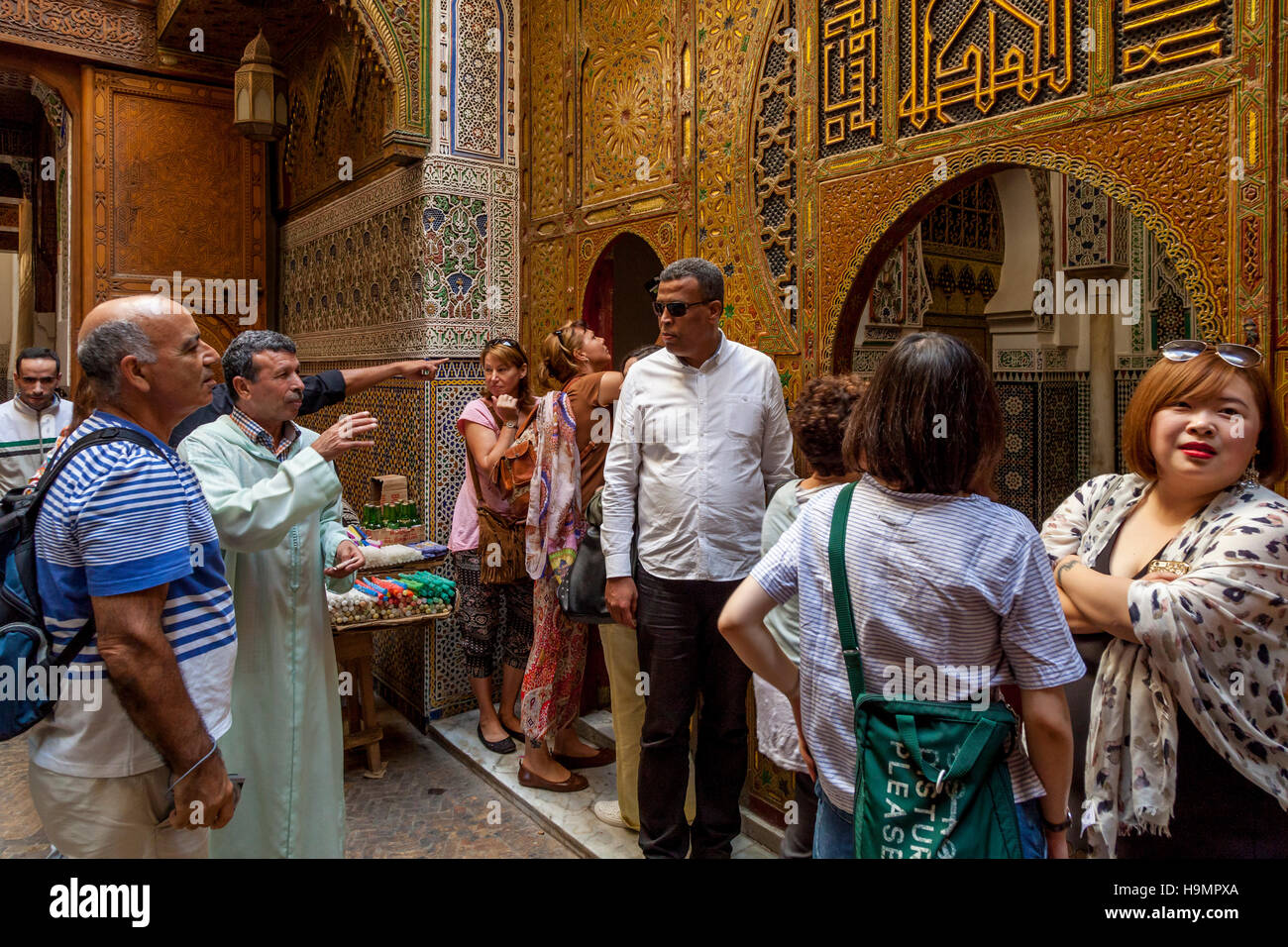 Touristen und A Tour Guide außerhalb der Zaouia Moulay Idriss 2 Moschee und Schrein, Fes el Bali, Fes, Marokko Stockfoto