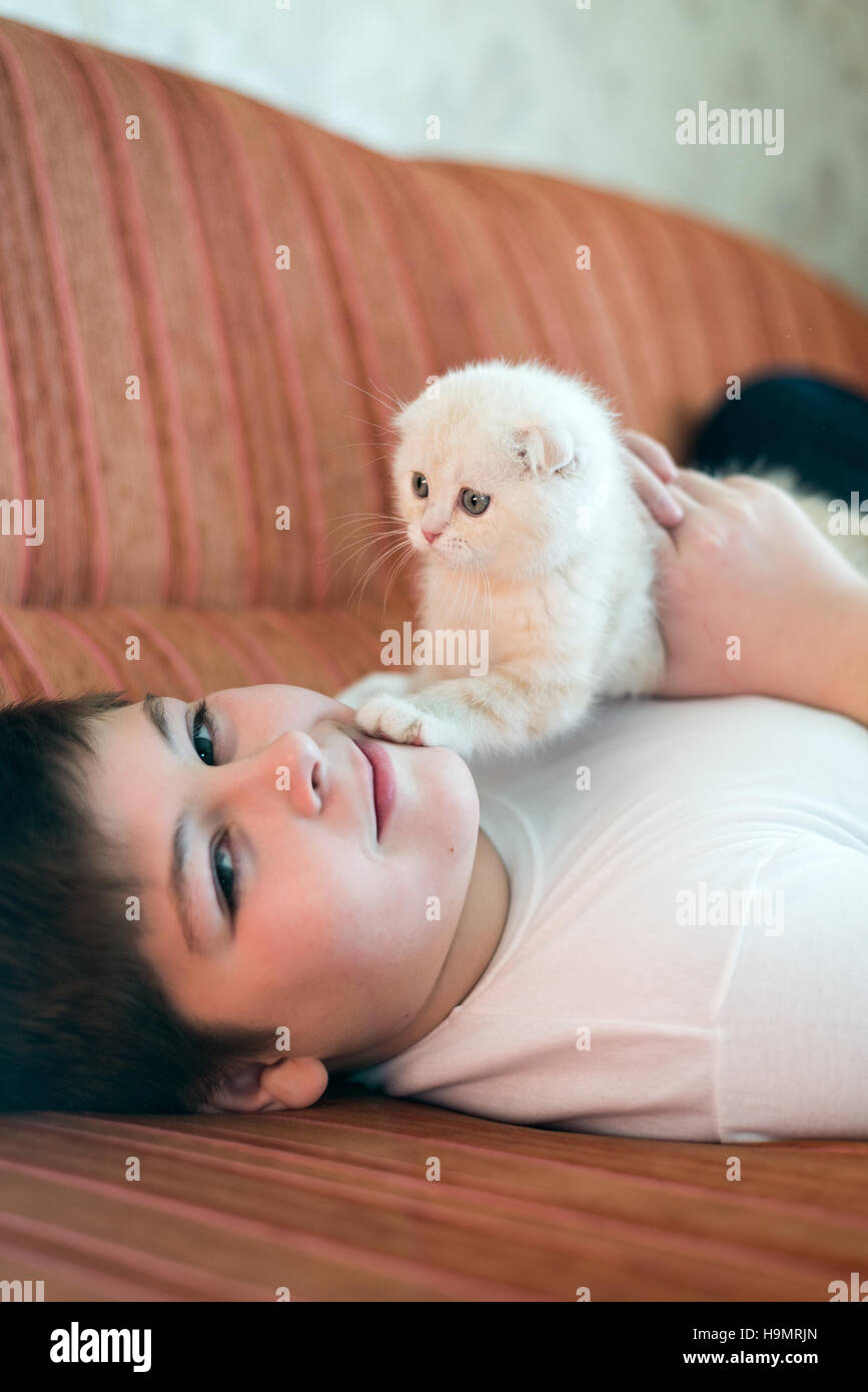 Teenboy mit einem Kätzchen auf Couch liegen Stockfoto