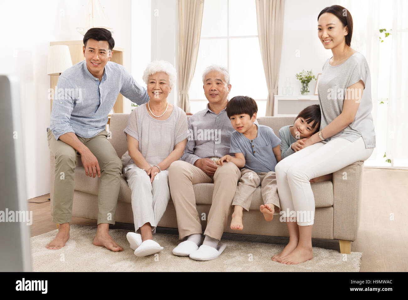 Glückliche Familie vor dem Fernseher im Wohnzimmer Stockfoto