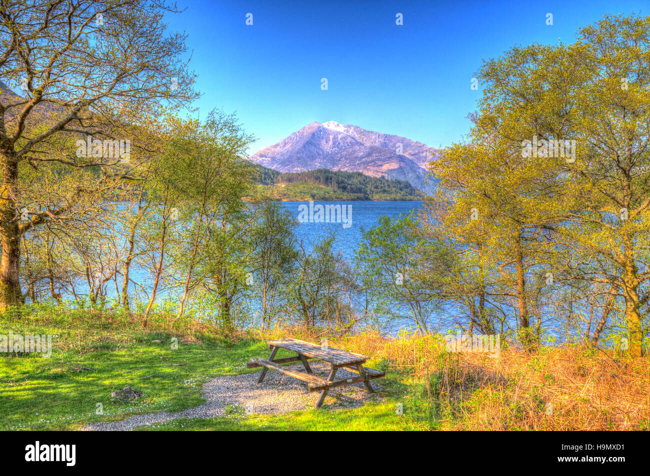 Picknick-Sitzbank anzeigen Loch Leven Schottland Schottisches Hochland um Schnee gekrönt Berg in bunte HDR Stockfoto