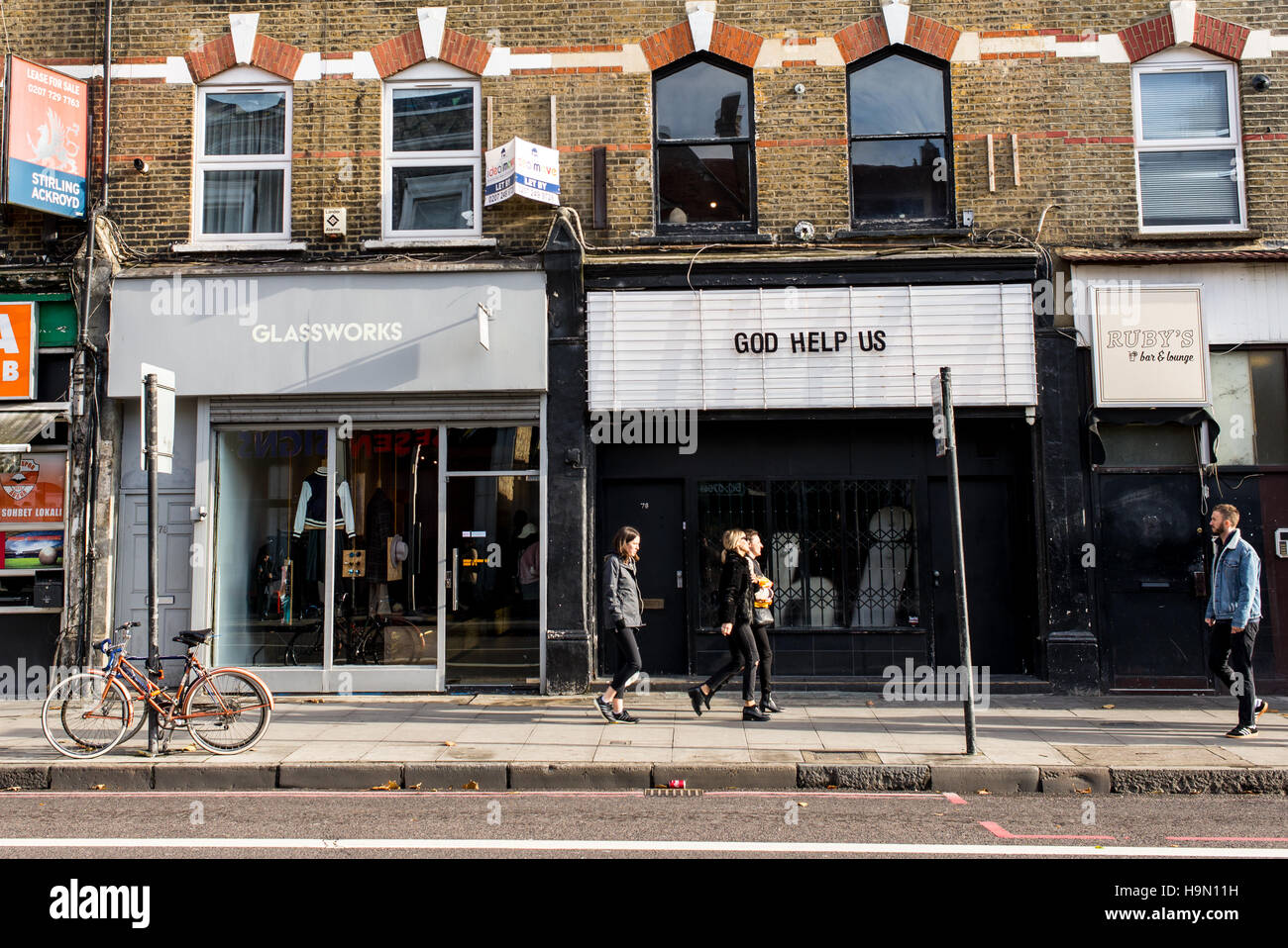 Trendige junge Menschen wandern in Stoke Newington Road vor coole Indie-Geschäften. In Dalston, East London gedreht. Stockfoto