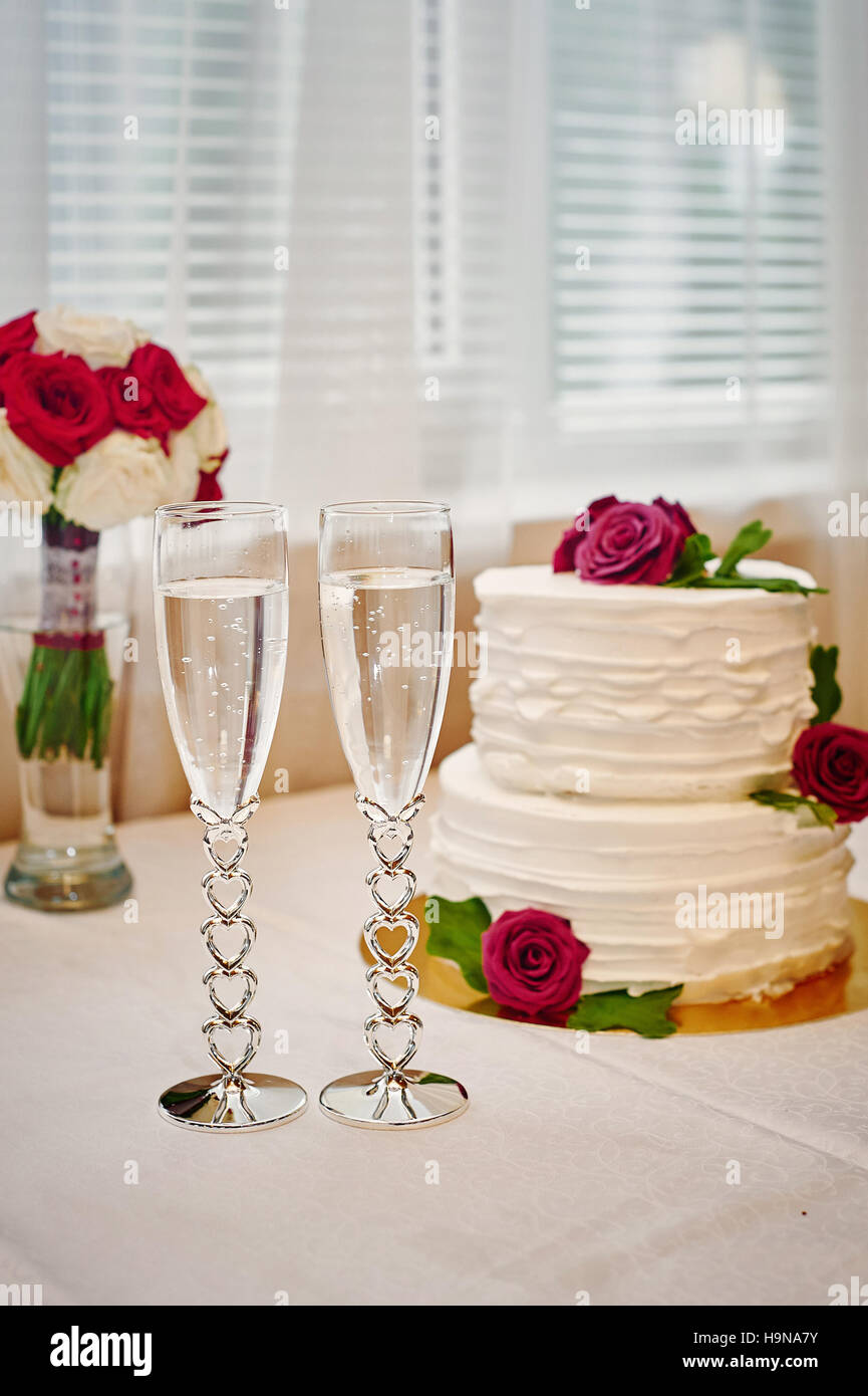 zwei Gläser Champagner und Hochzeitstorte auf dem Tisch Stockfoto