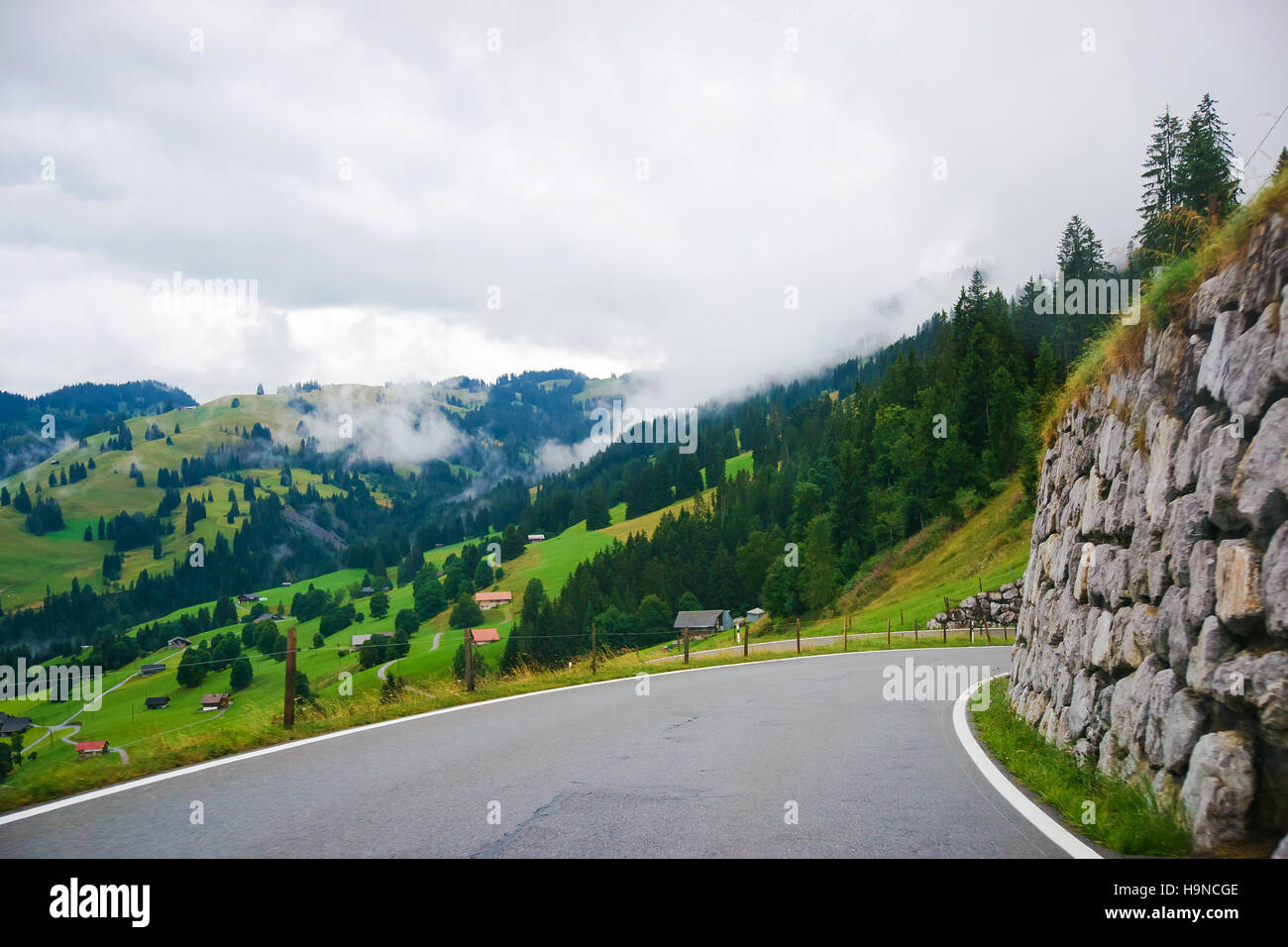 Fahrbahn im Dorf Boltigen mit Schweizer Alpen am Jaun-Pass in Fribourg Kanton der Schweiz. Stockfoto