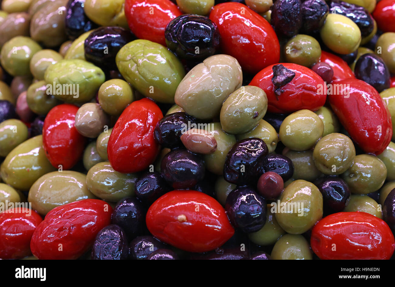 Mischung aus sortierten ganzen italienischen Oliven (schwarz, grün, rot) in Öl in der Nähe bis Markt Stall Einzelhandel, erhöhte Ansicht Stockfoto