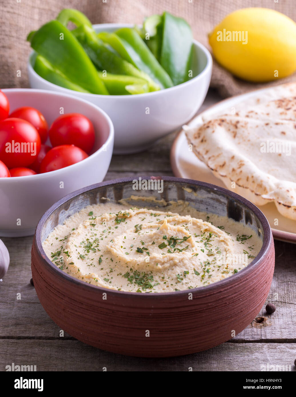 Humus in hausgemachte Schüssel Chapati, Zitrone und Gemüse. Stockfoto