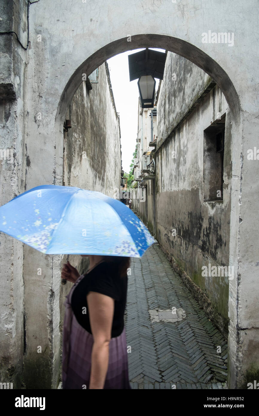 Eine Frau in einer Straße von Wuzhen, einer antiken Stadt auf dem Wasser Stockfoto
