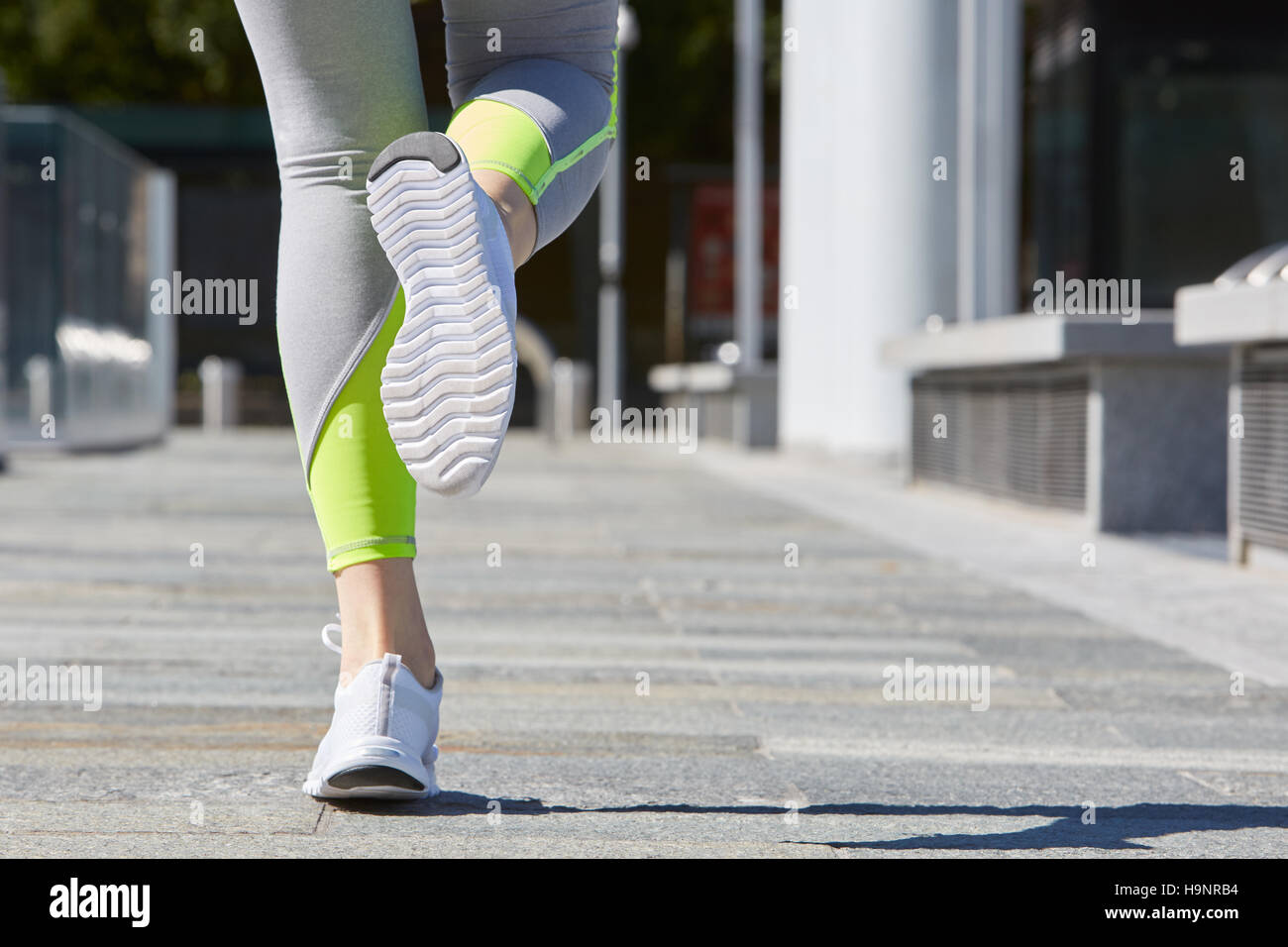 Frau läuft in der Stadt an einem sonnigen Vormittag im freien Stockfoto