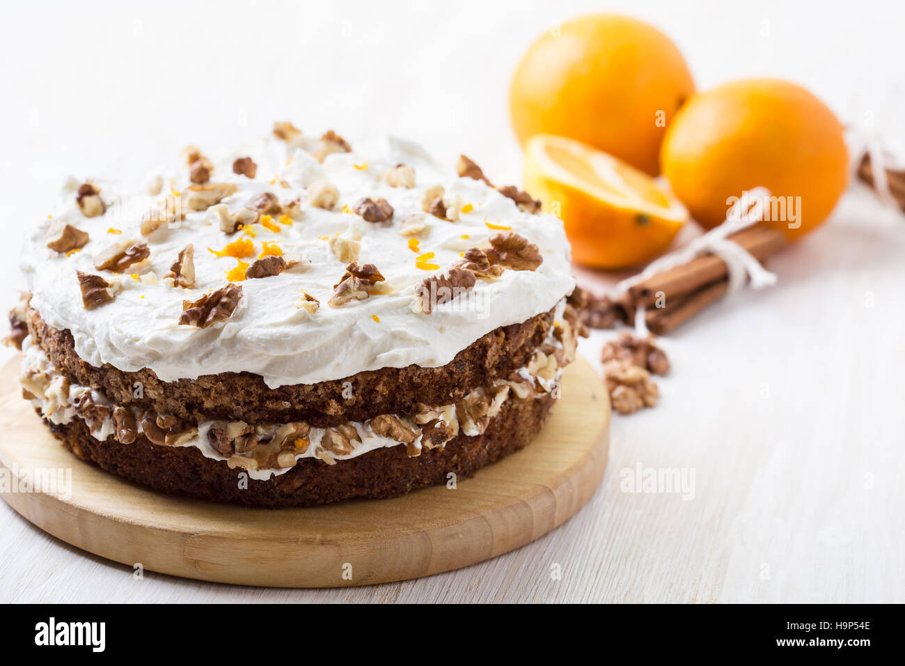 Hausgemachte Karotte und Walnuss-Kuchen mit pikanter orange Sahnehäubchen auf weißer Holztisch Stockfoto