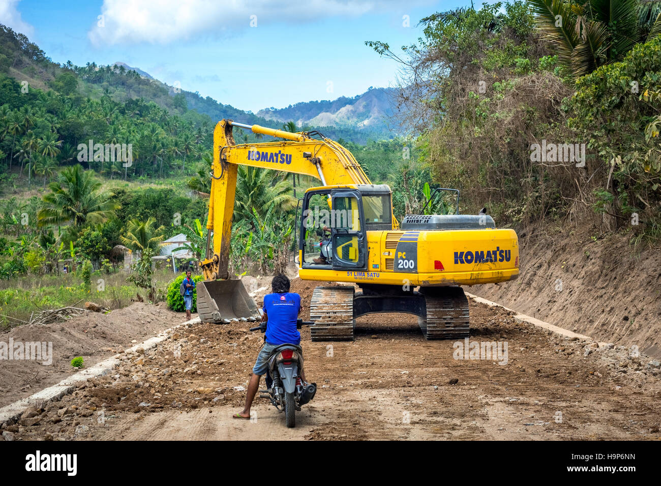 Ein Hydraulikbagger wird für die Landschaftsgestaltung auf einer Baustelle für Straßen in der Nähe von Atadei in Lembata, East Nusa Tenggara, Indonesien, verwendet. Stockfoto