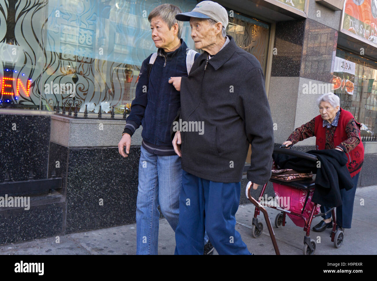 3 ältere asiatische Amerikaner gehen in Chinatown, Downtown Flushing, Queens, New York City Stockfoto