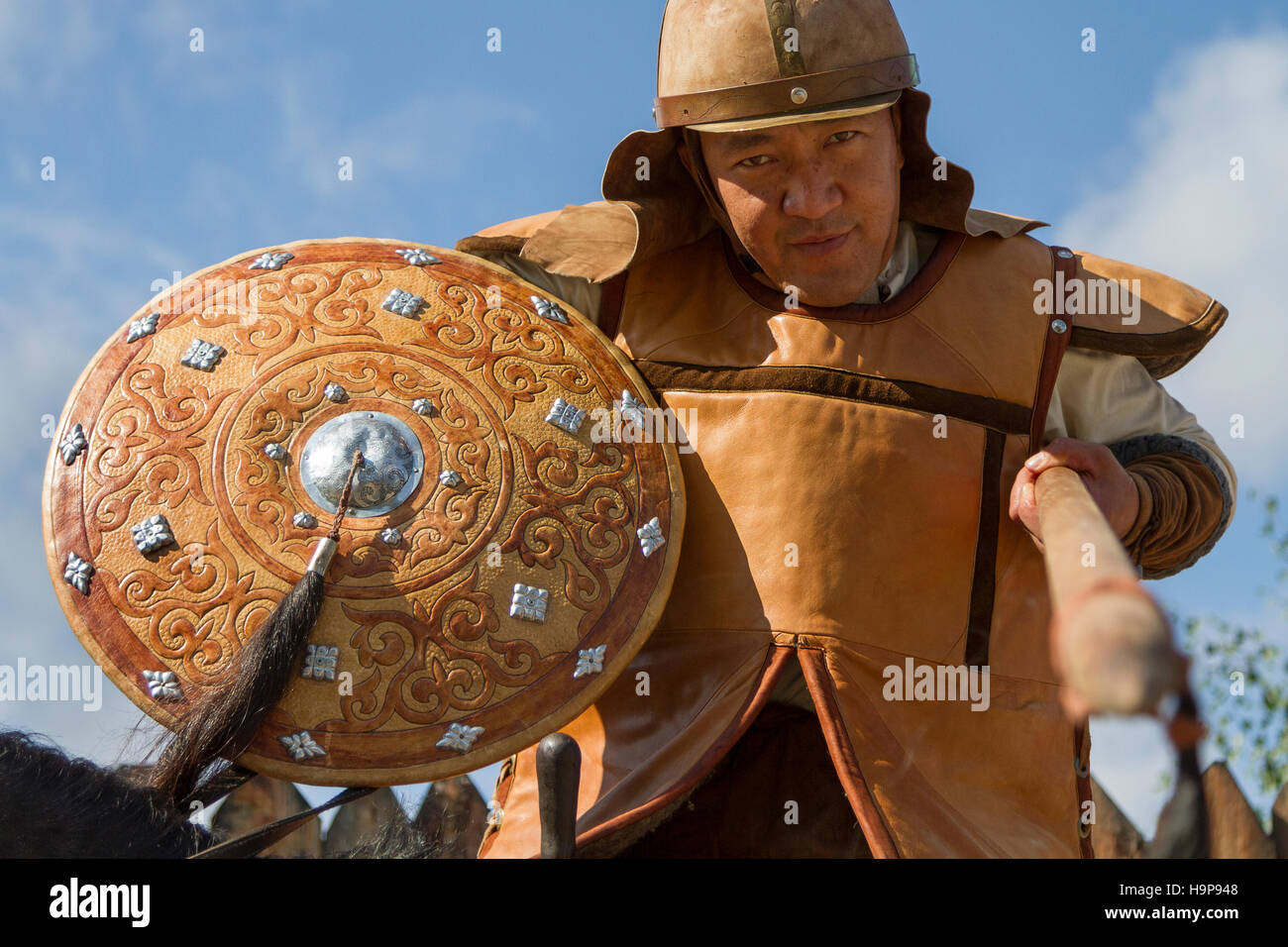 Kasachischer Mann in traditioneller Kriegskleidung mit Speer in der Hand, bei einer Show der kasachischen Nationalspiele in Almaty, Kasachstan Stockfoto