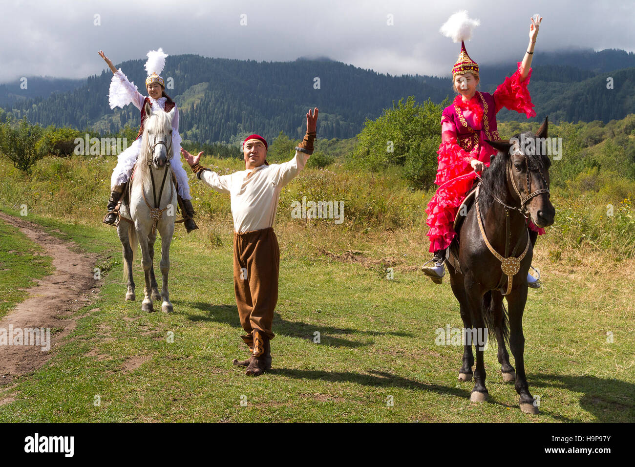 Einheimische Frauen und Mann in traditioneller Kleidung bei nationalen Folklore spielen in Almaty, Kasachstan. Stockfoto