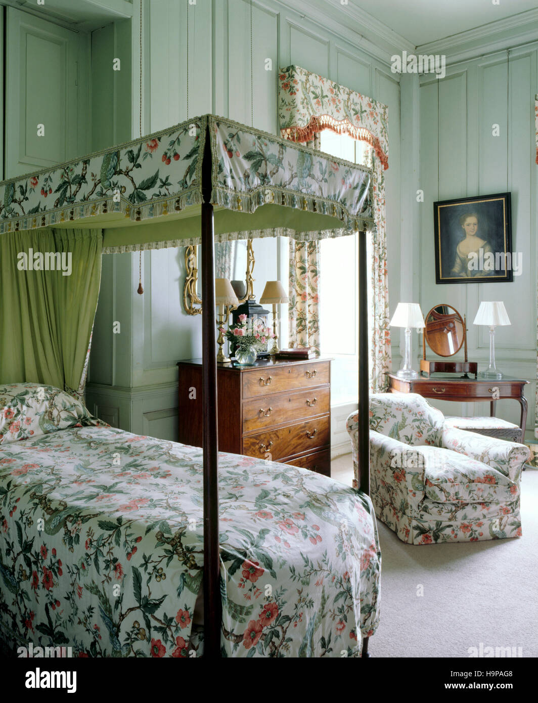 Schlafzimmer mit Himmelbett im Antony House, Vorhänge, Schminktisch, Brust und ein Porträt zeigt. Stockfoto